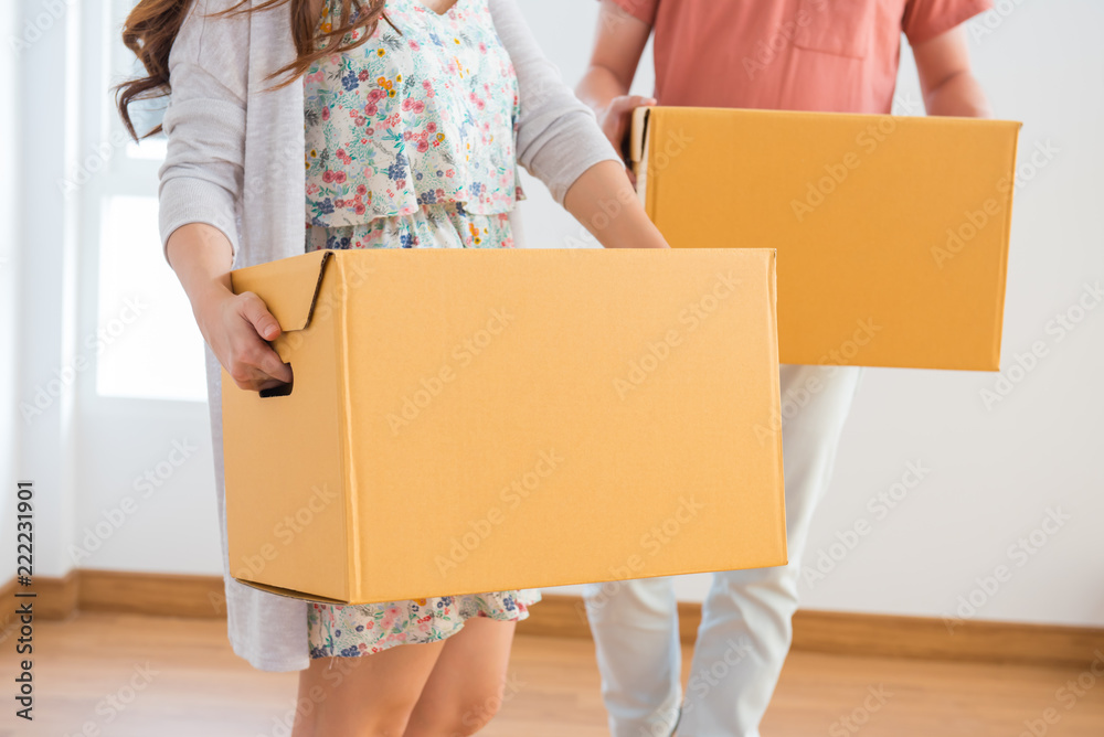 夫妻俩买了一套新房子。把箱子搬进房子里。