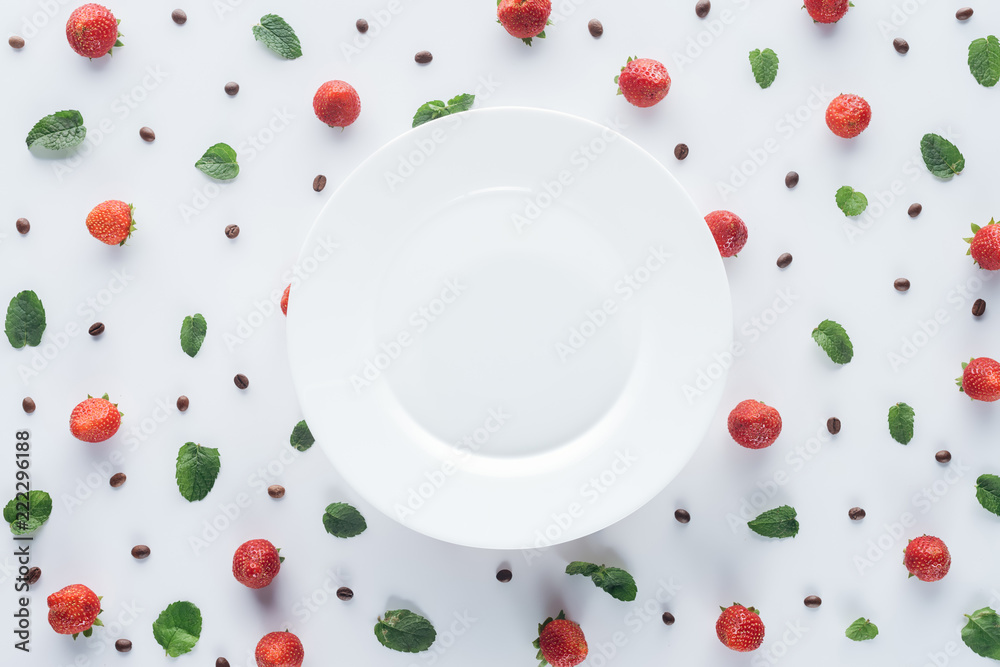 白色表面上空盘子周围成熟草莓的俯视图
