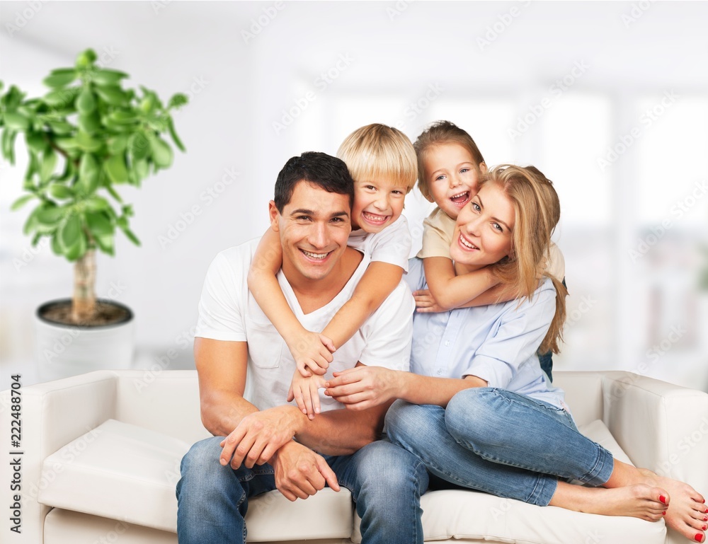 美丽的微笑家庭坐在房间背景的沙发上