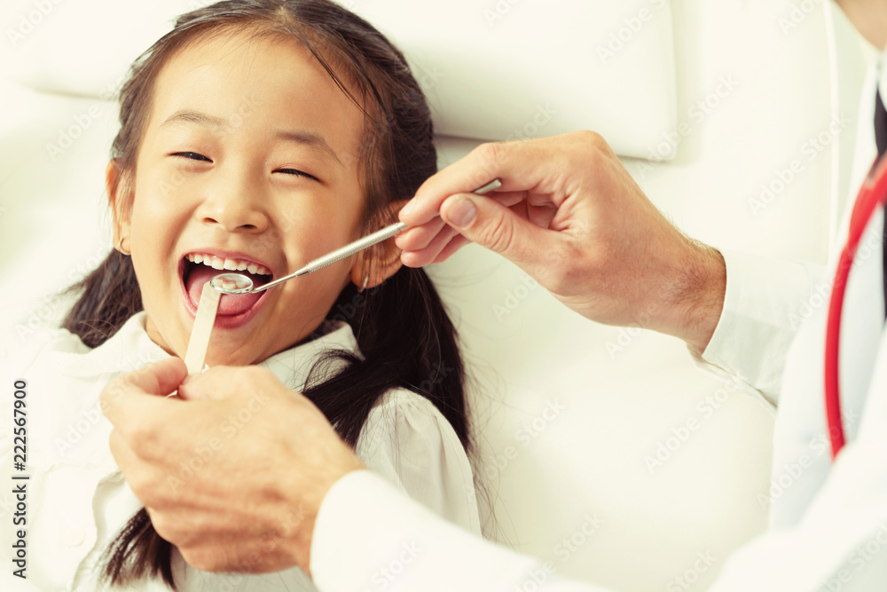 牙医在牙科诊所检查儿童牙齿。