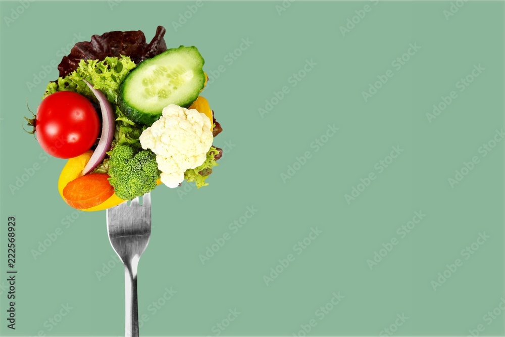 蓝底叉子上的新鲜生蔬菜