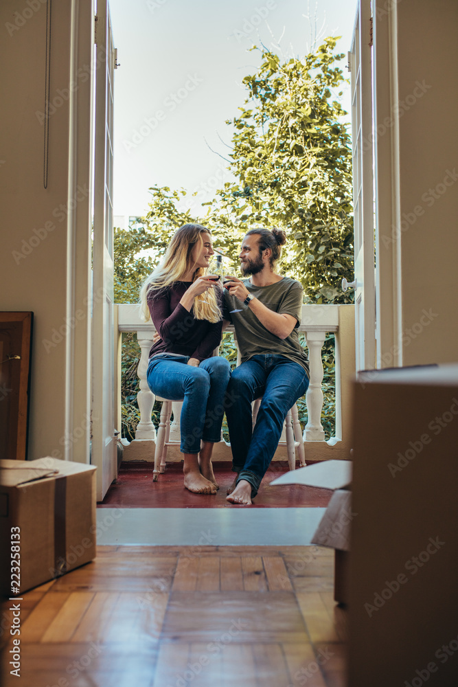 一对夫妇坐在阳台上举杯庆祝