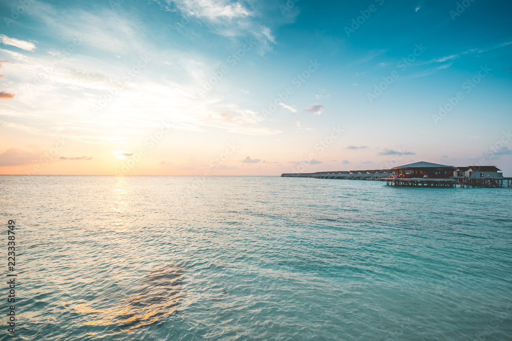马尔代夫热带岛屿度假胜地水上美丽的别墅，碧绿的大海和日落，瓦卡