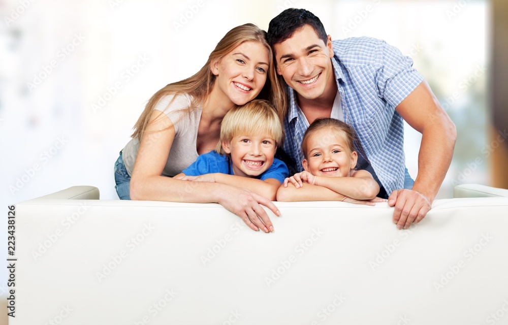 美丽微笑的一家人坐在背景沙发上