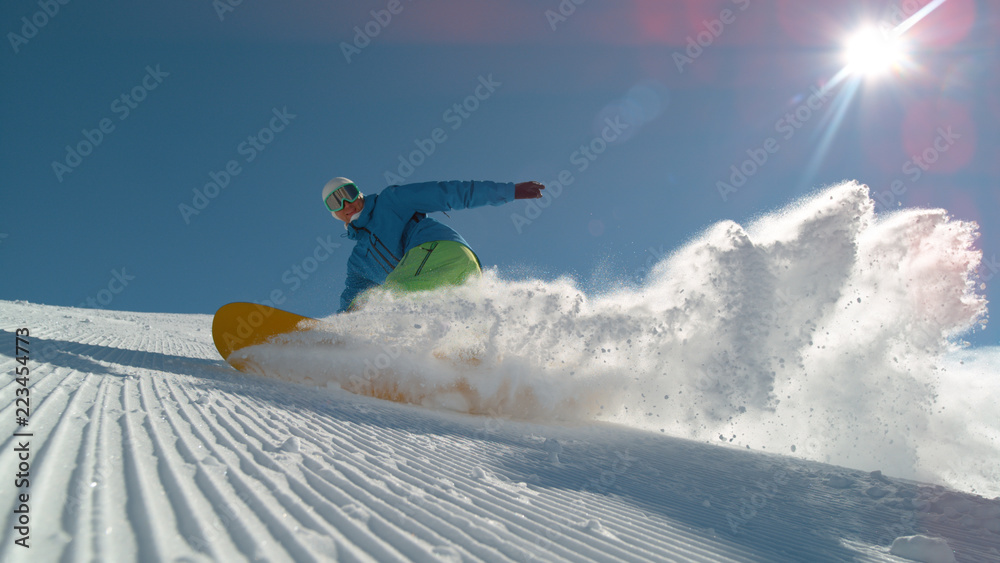 特写：微笑的单板滑雪运动员转身并将雪喷入相机