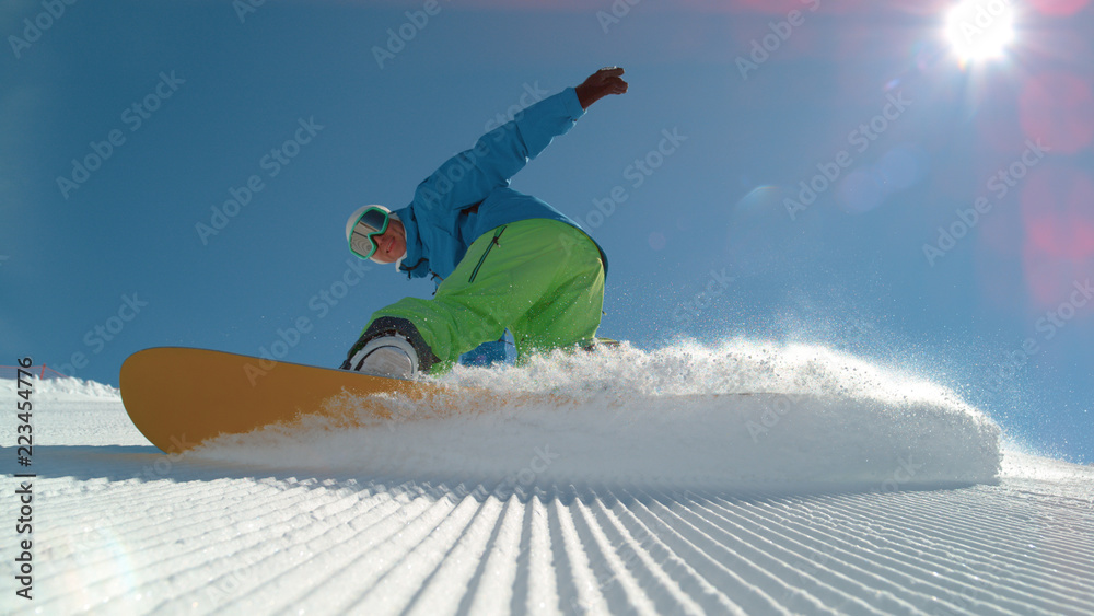 特写：兴高采烈的单板滑雪运动员雕刻并向镜头喷射雪