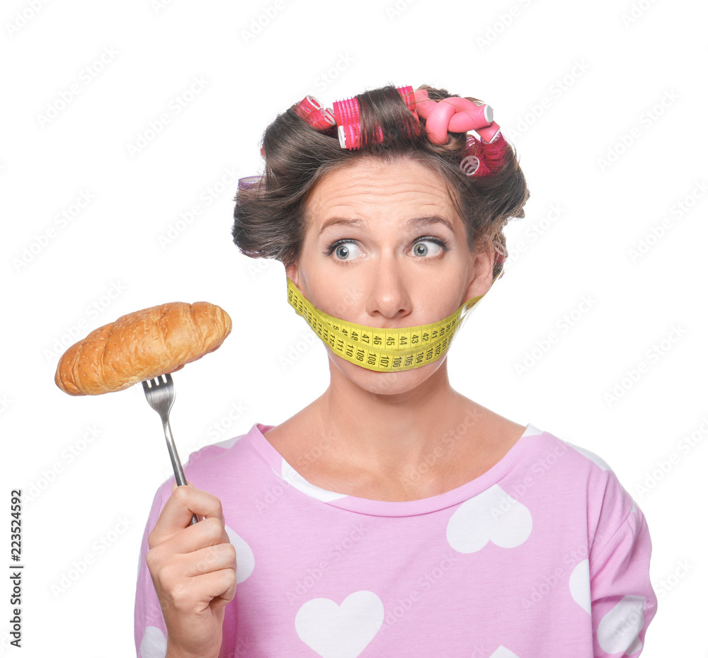 情绪激动的女人，嘴上缠着卷尺，白底美味的羊角面包。饮食c