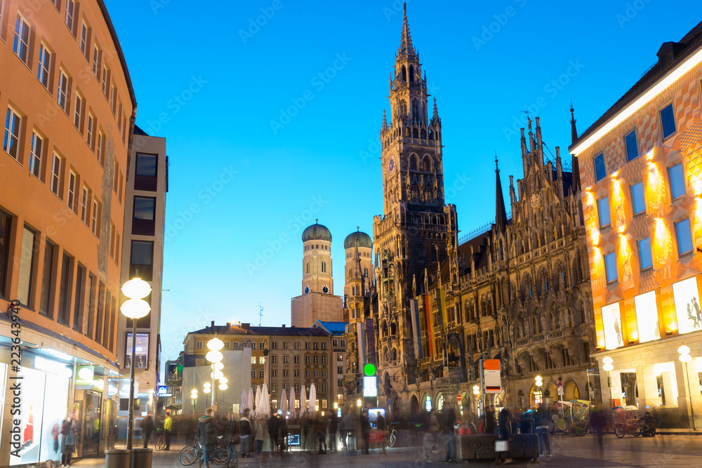 People walking at Marienplatz square and Munich city hall in night in Munich, Germany. Cafes, bars, 
