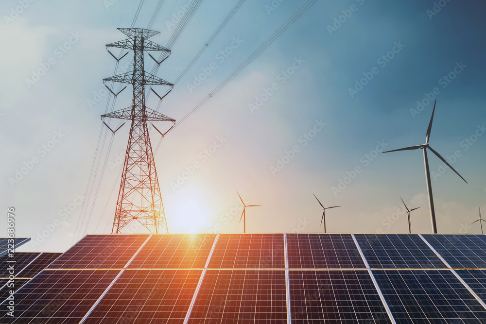 Solar panels with electricity pylon and wind turbine Clean power energy concept. sunset background