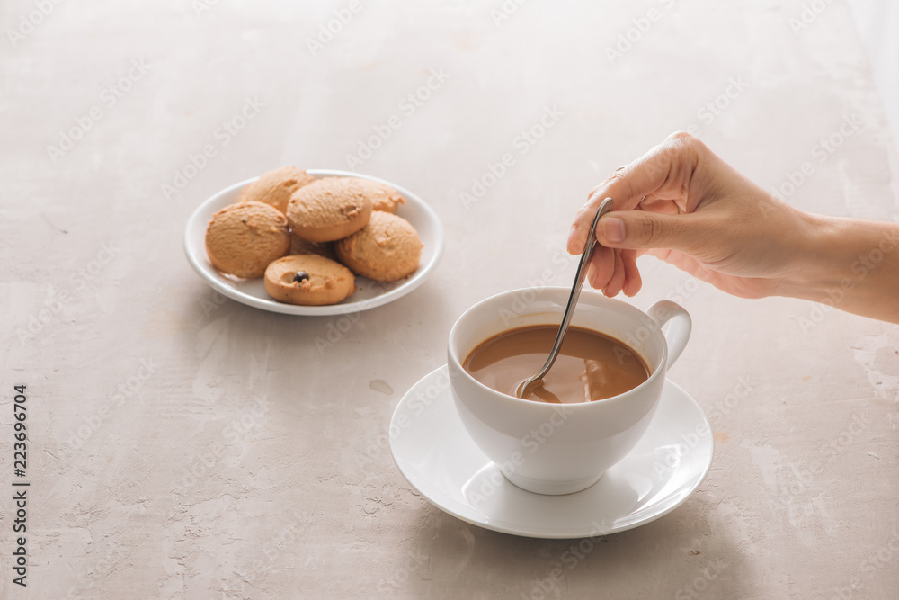 饼干和手动搅拌杯茶/咖啡的特写