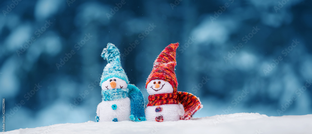 蓝色背景下松软雪地上的小雪人