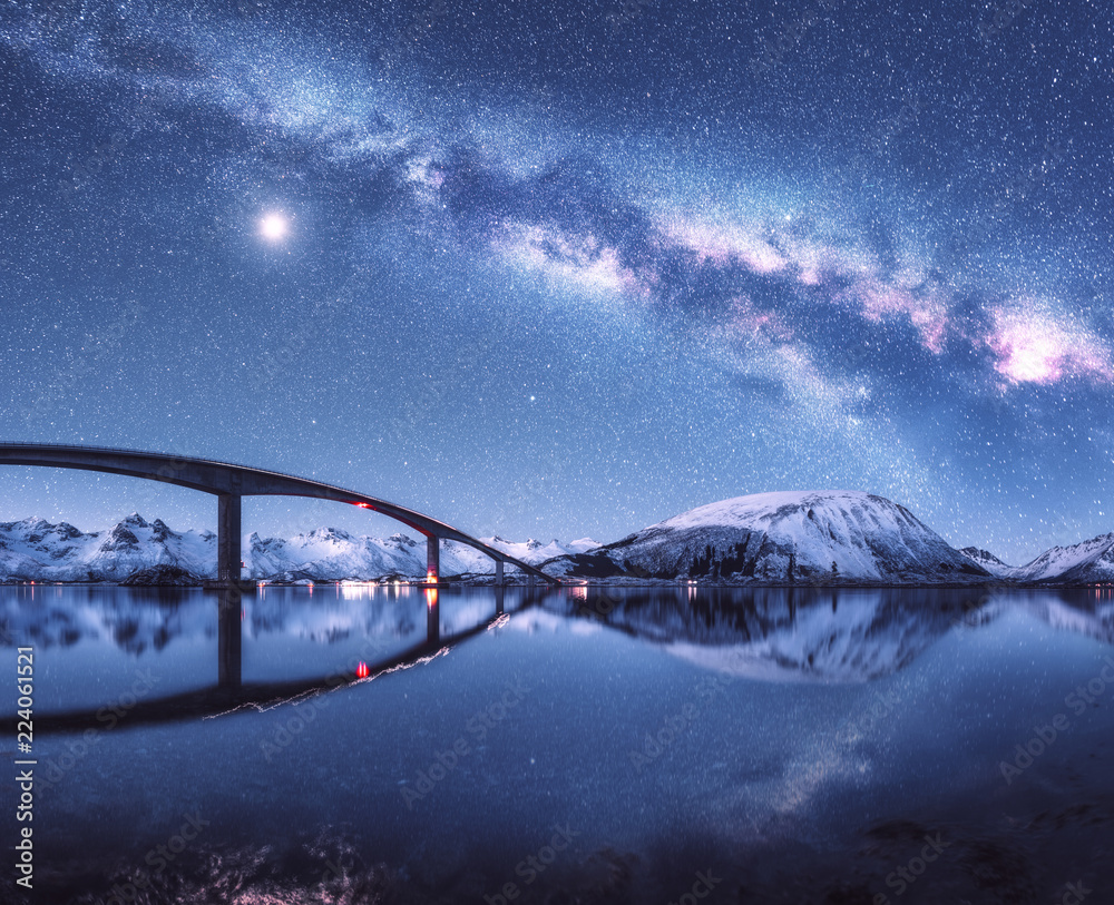 桥和星空，白雪覆盖的山脉上的银河映照在水中。夜景
