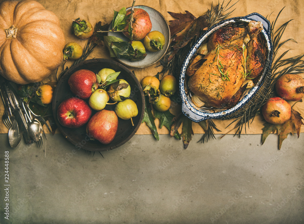 感恩节餐桌。烤鸡或火鸡、秋天的水果、南瓜、餐具等。
