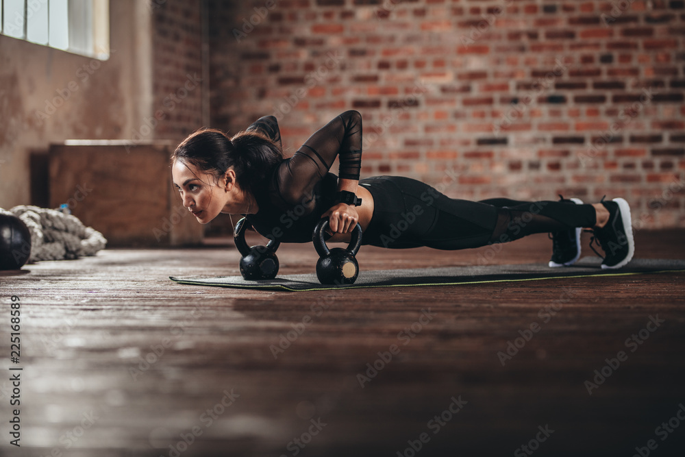 Fit female doing intense core workout in gym