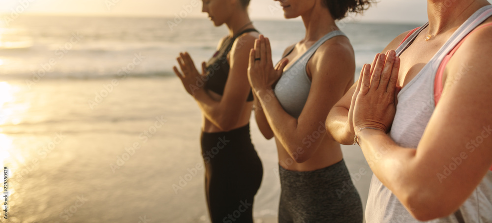 妇女清晨在海滩上练习瑜伽