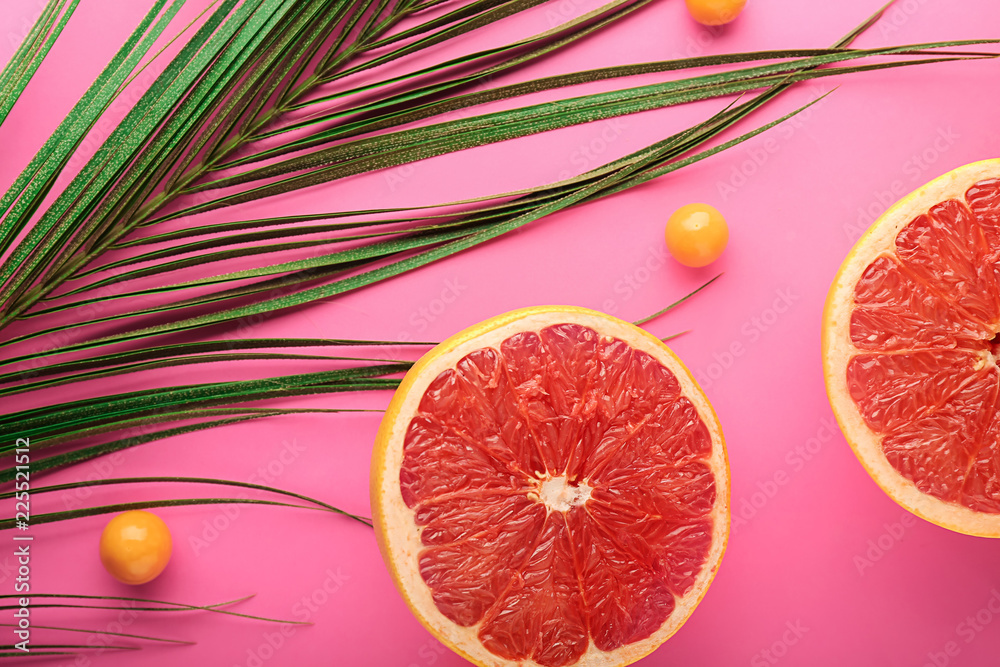 彩色背景的成熟多汁葡萄柚片和棕榈叶