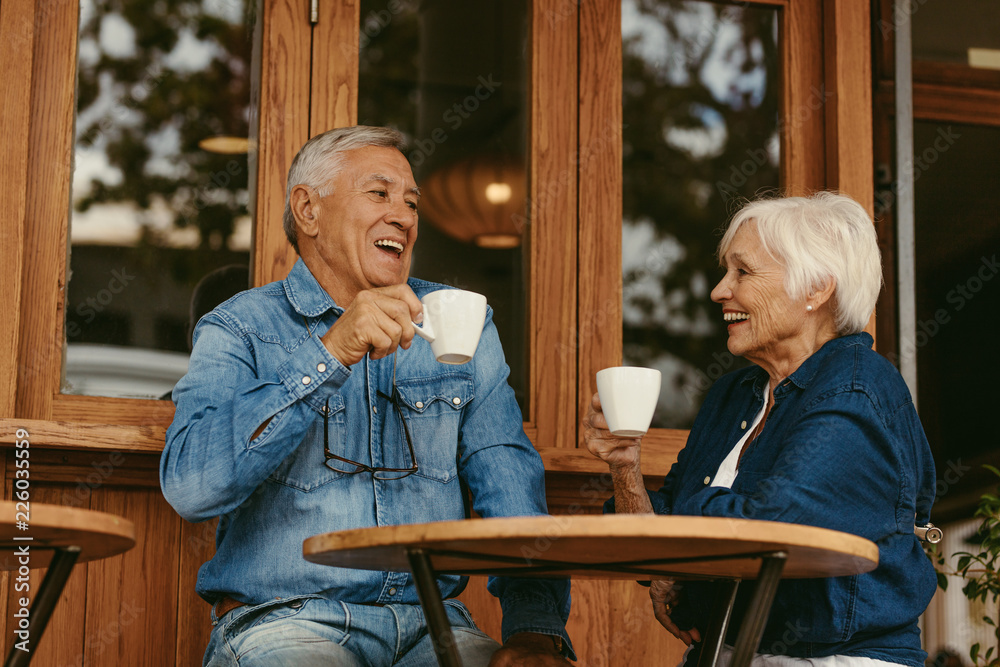 微笑的老年夫妇在咖啡馆喝咖啡