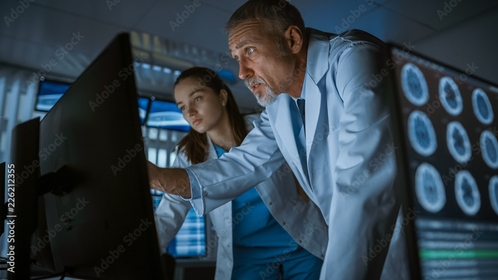 两位医学科学家/神经学家，在现代实验室的个人电脑上交谈和工作