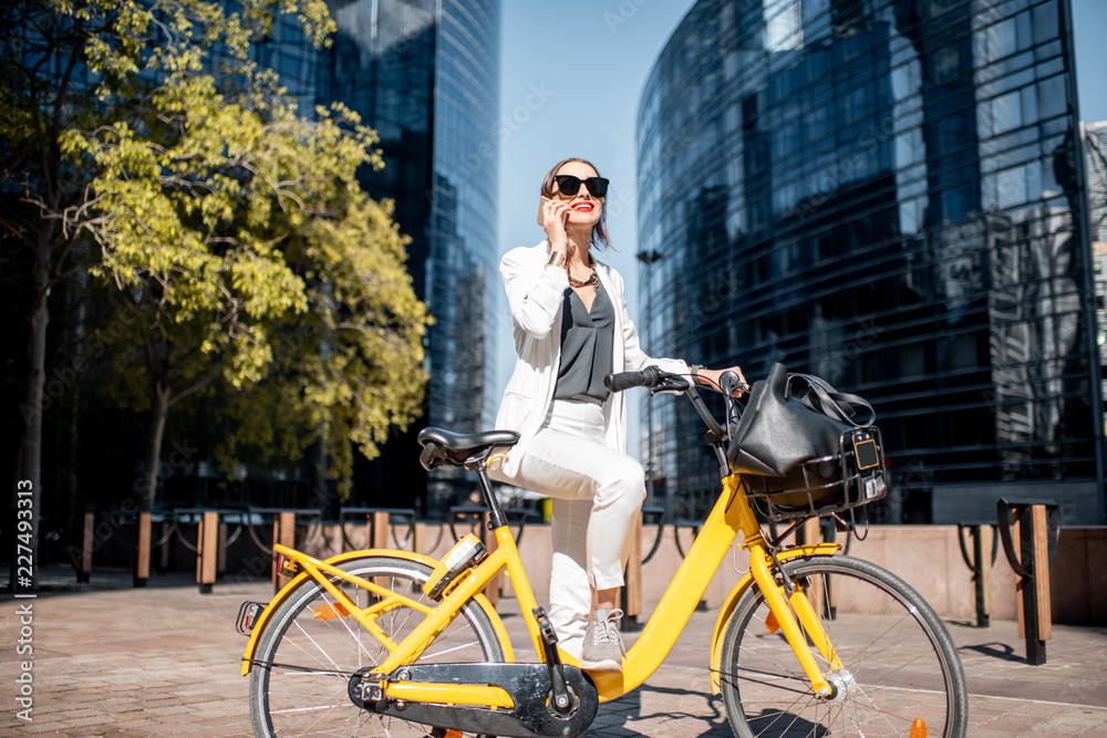 一位身穿白色西装、骑着自行车站在金融区w的时尚商务女性的肖像
