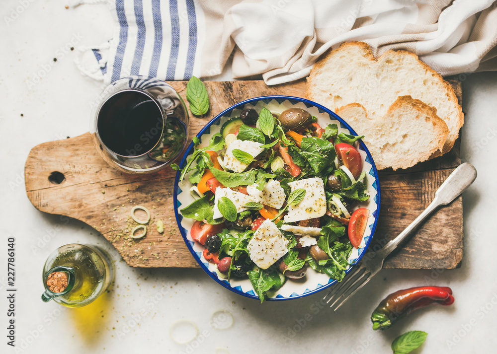 传统希腊沙拉，配羊乳酪、瓶装橄榄油、橄榄和一杯re