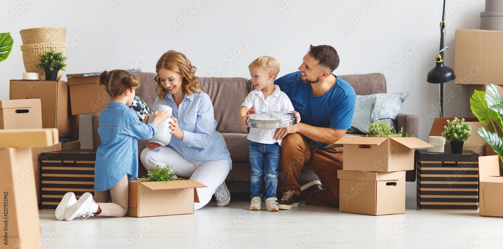 幸福家庭的母亲、父亲和孩子搬到新公寓，打开箱子。