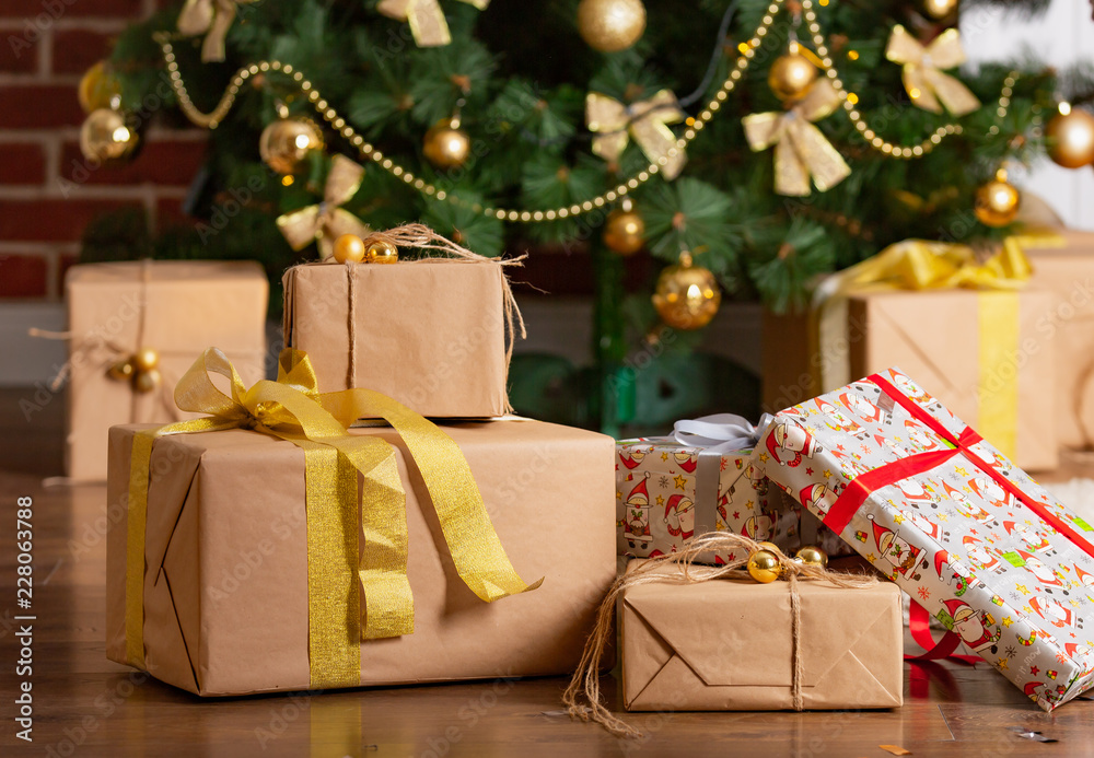 t地板上的圣诞树下摆放着设计师纸和亮丝带制成的新年礼物