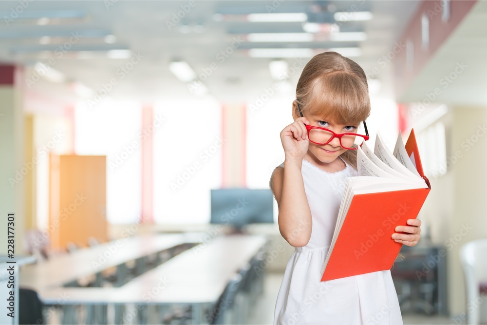 Education and school concept -  little student girl with book at