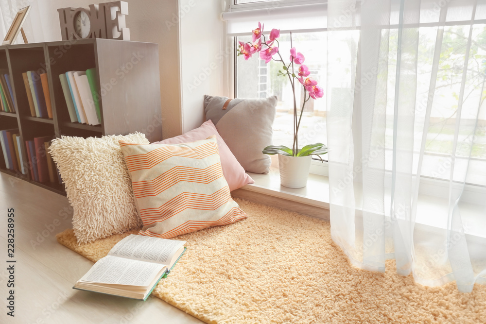 舒适的休息场所，配有柔软的枕头和靠近窗户的书