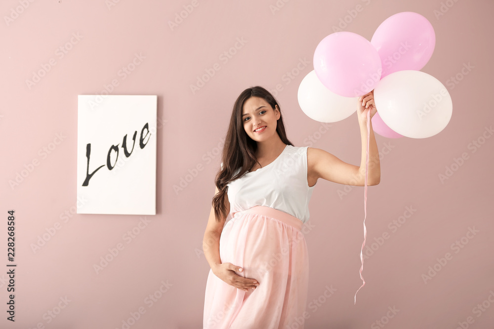 美丽的孕妇，彩色背景上有气球