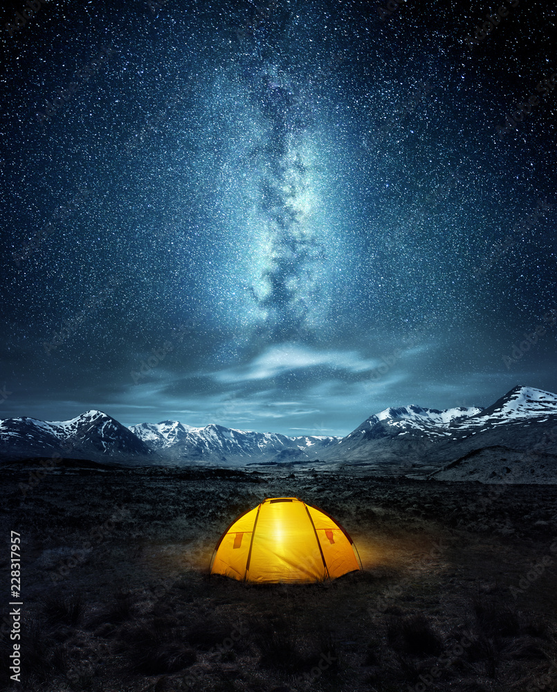 在荒野中露营。在银河系发光的夜空下搭起的帐篷。