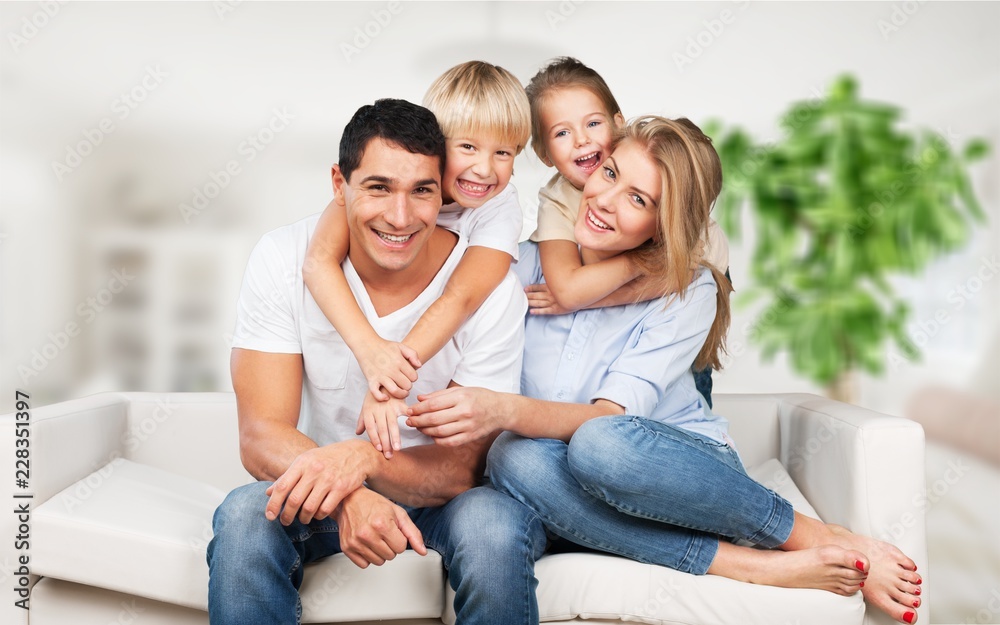 美丽微笑的一家人坐在家里的沙发上