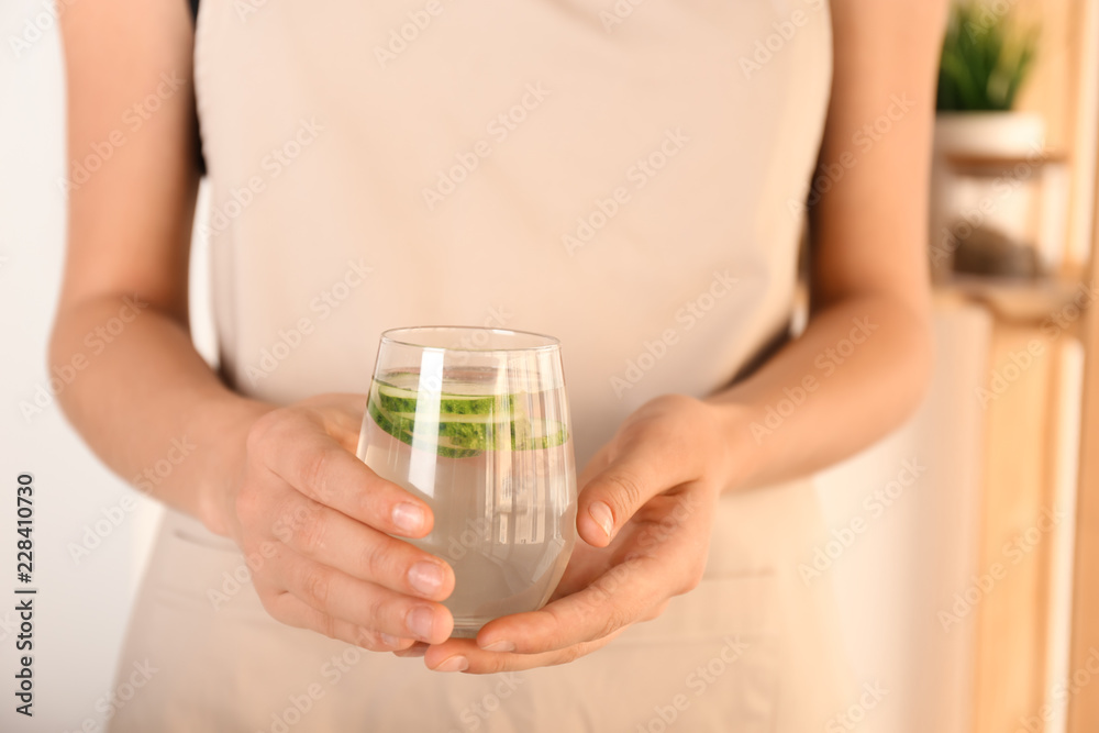 女人拿着一杯美味的新鲜黄瓜水，特写镜头