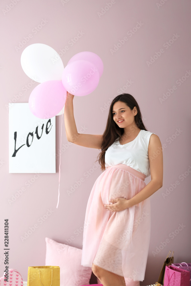 美丽的孕妇，彩色背景上有气球