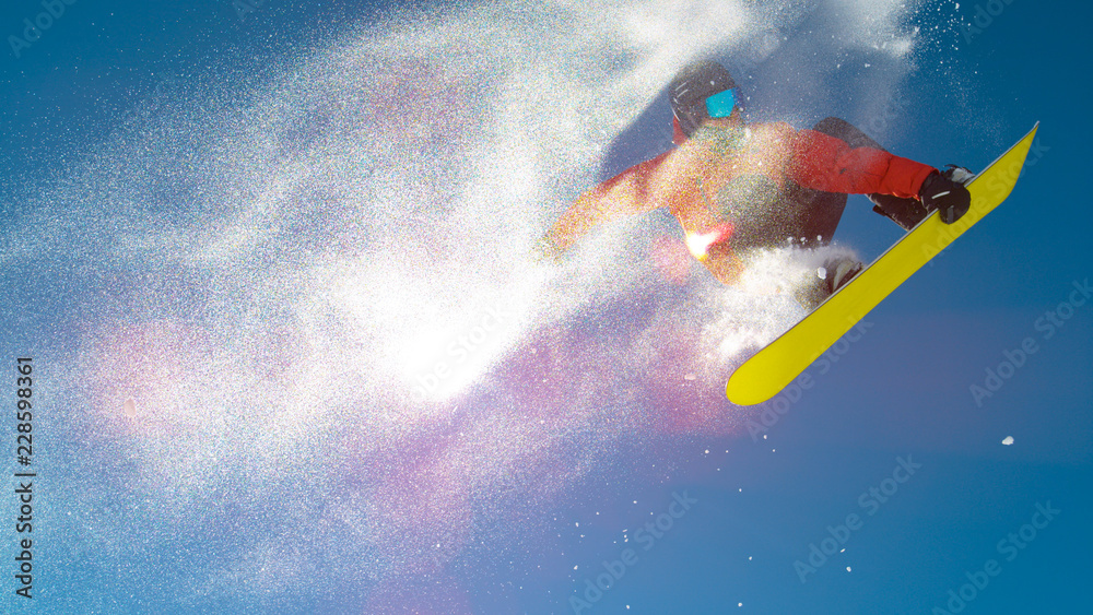 镜头闪光：一个滑雪板男子在玩把戏时在空中留下了雪痕。