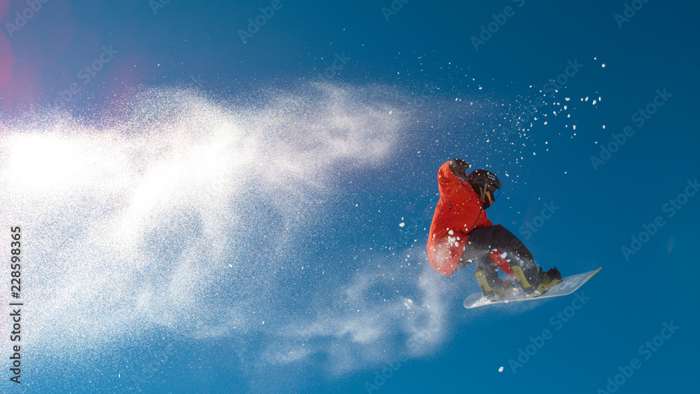 仰卧起坐：一名运动员在空中跳跃，在他的滑雪板上做了一个很酷的动作。