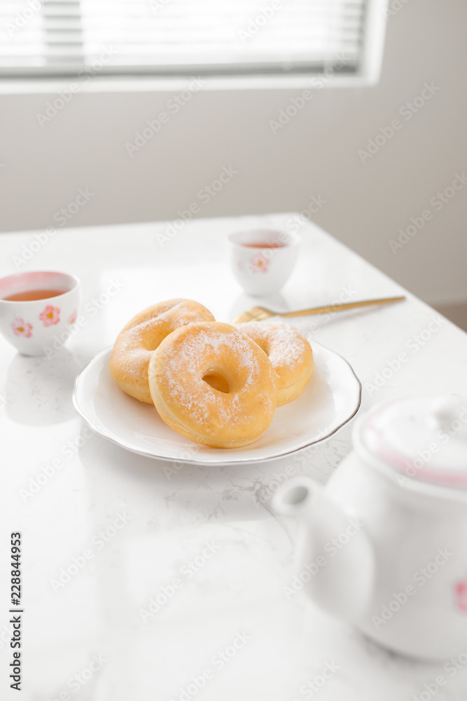 经典甜甜圈。早餐在家里客厅的桌子上喝茶。