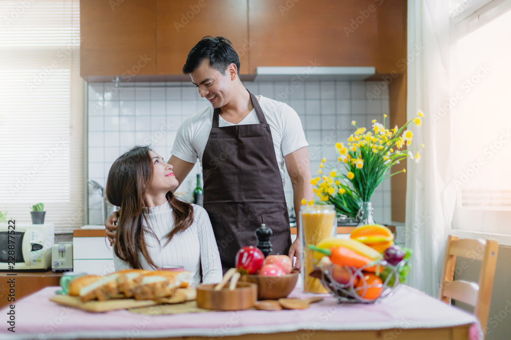 甜蜜的亚洲夫妇幸福时刻在厨房里一起准备早餐