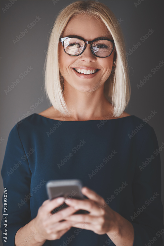 微笑的女商人用手机对着灰色的后背