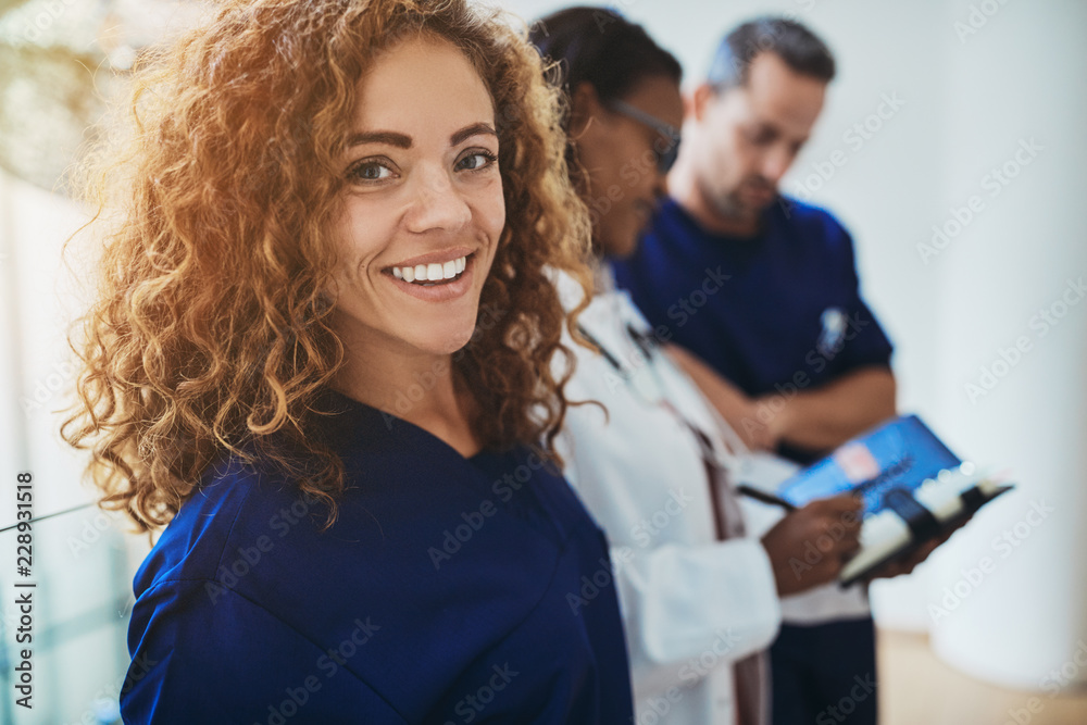 微笑的年轻医学实习生与医生站在医院里