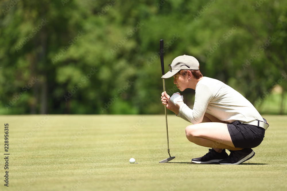 女子高尔夫球手将高尔夫球放在草地上的检查线