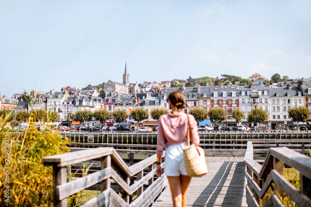 在诺姆著名的法国度假胜地特鲁维尔市美丽的河畔欣赏美景的女人