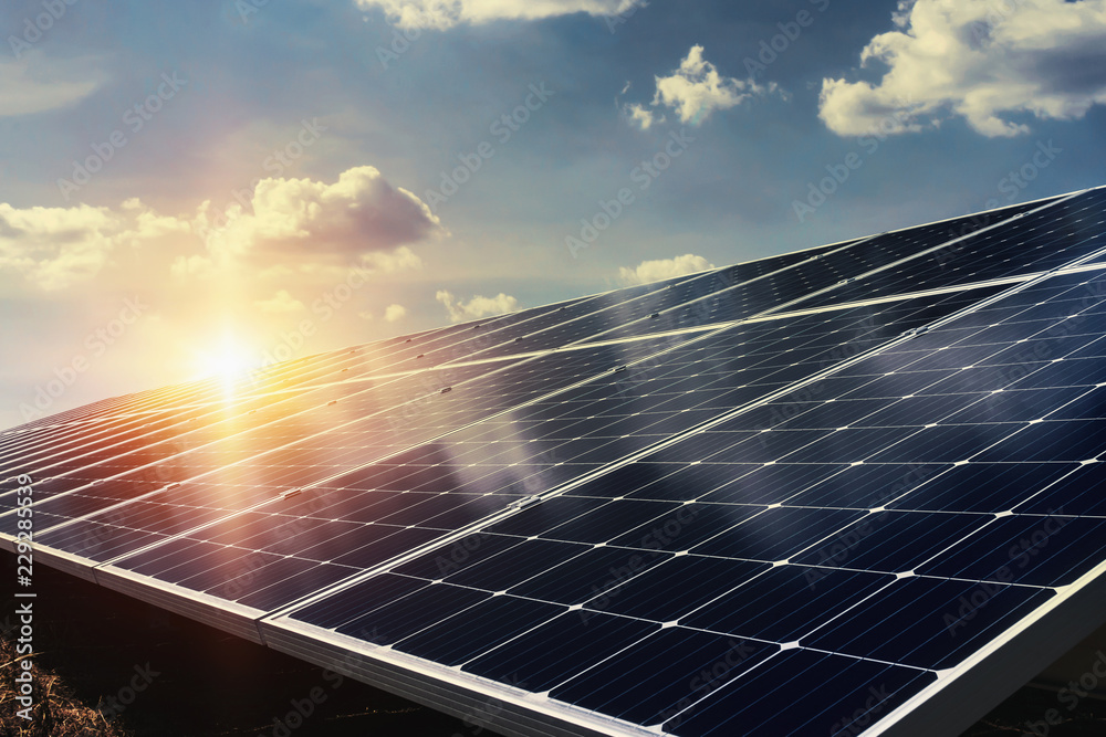 阳光和蓝天背景的太阳能电池板。大自然中的清洁能源概念