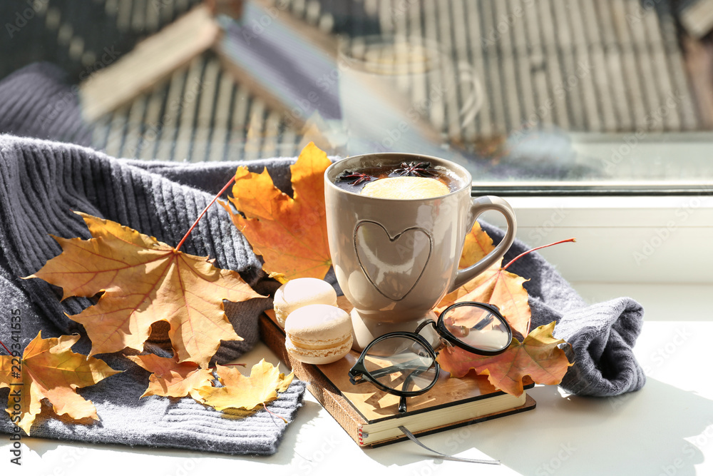 一杯芳香的茶，书，温暖的毛衣和窗台上的秋叶