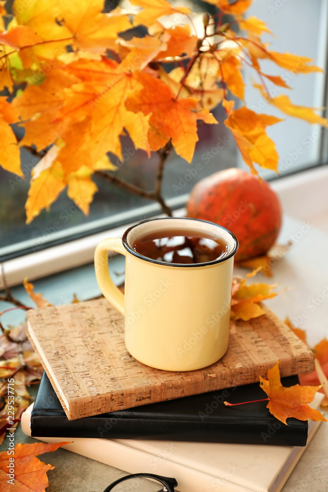 窗台上有秋叶的金属杯芳香茶