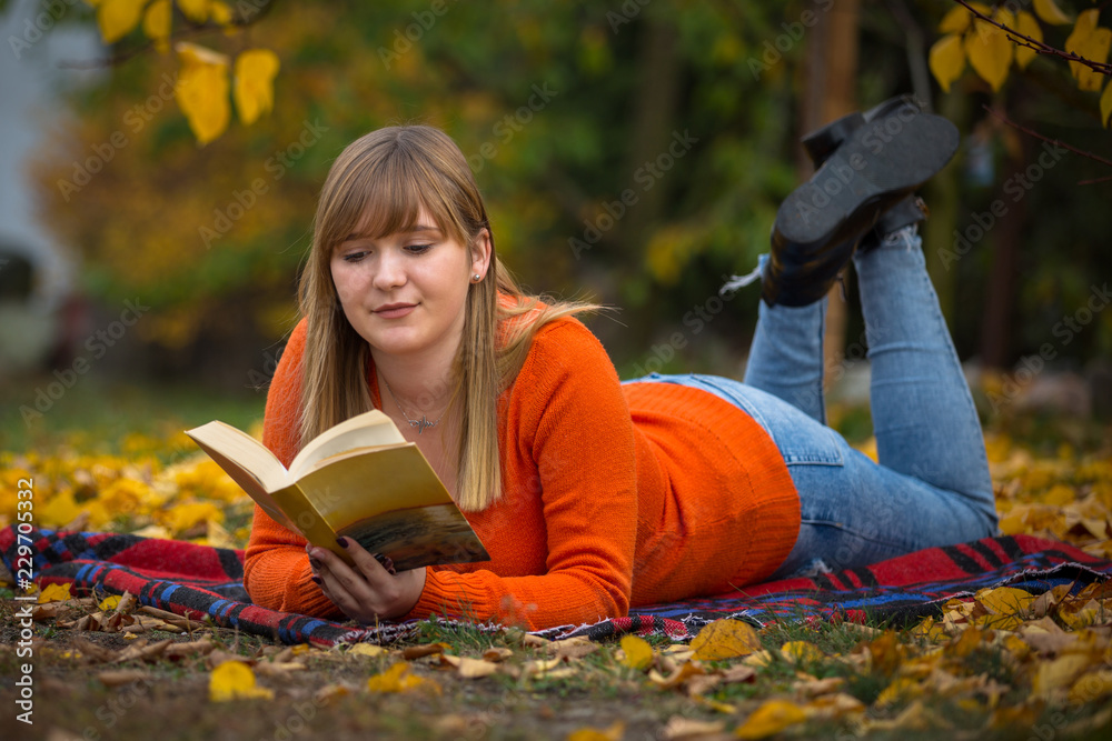少女在秋季公园看书