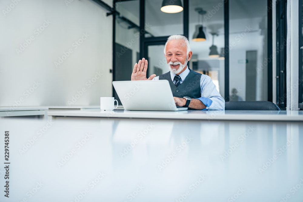 Senior businessman having video call on laptop. Copy space.