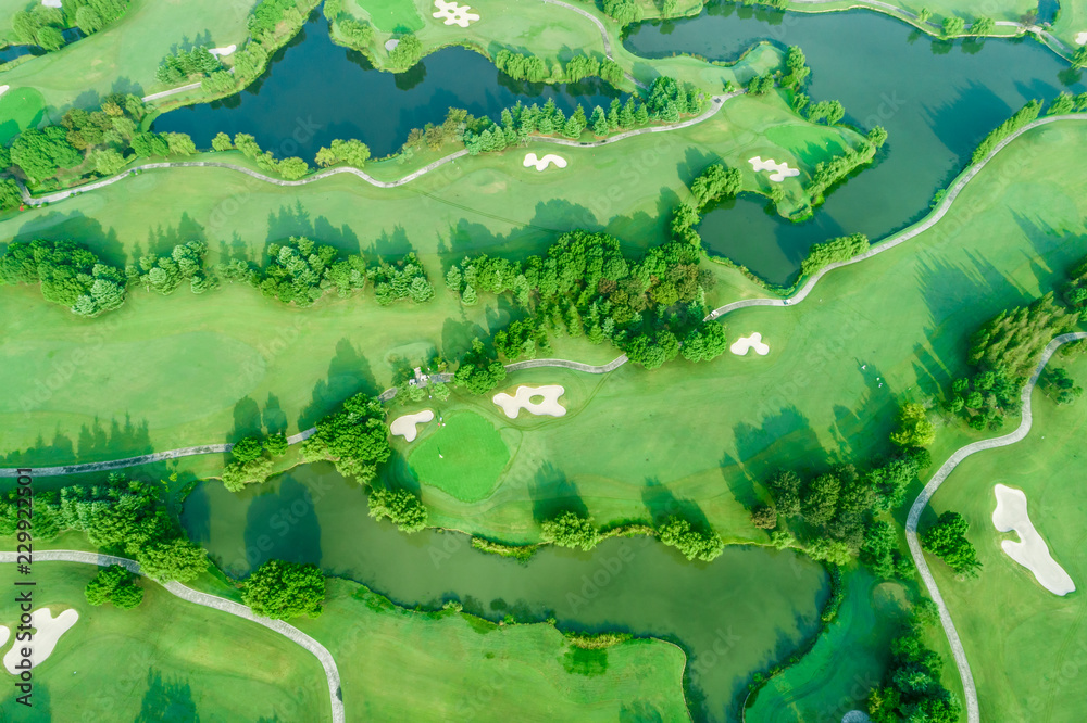 森林和高尔夫球场与湖泊的空中照片