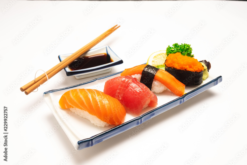 白色盘子上的寿司三文鱼、金枪鱼、寿司虾和芥末被隔离。选择性聚焦