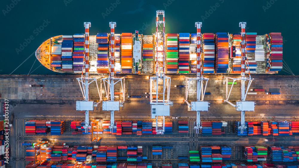 Aerial top view crane shipping container at night, cargo container ship carrying container import an
