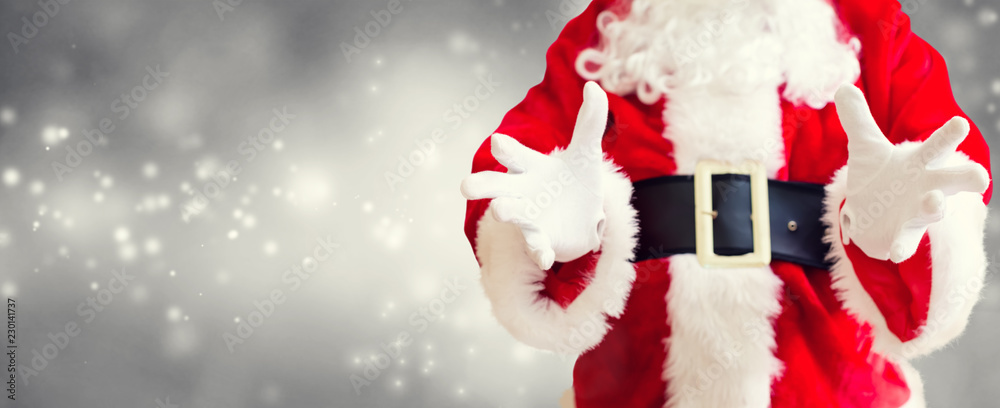 圣诞老人在闪亮的灯光背景上做出抱着的手势
